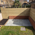 Enclosed back garden with brick wall and wooden fence